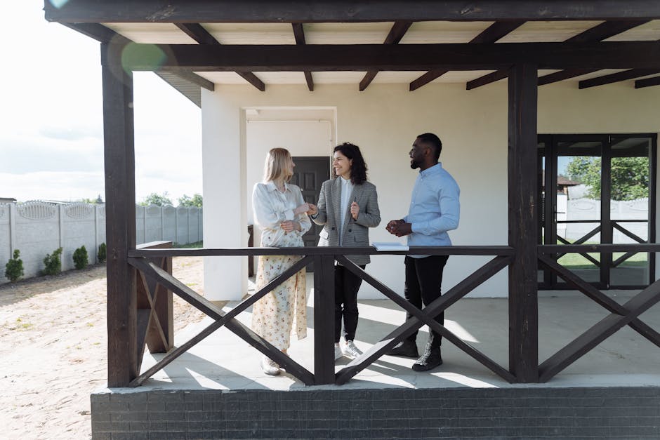 A real estate agent discussing property details with clients on a sunny porch